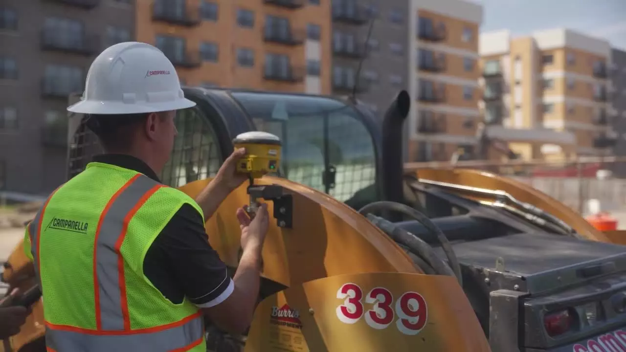 Contractor moving antenna onto a compact track loader